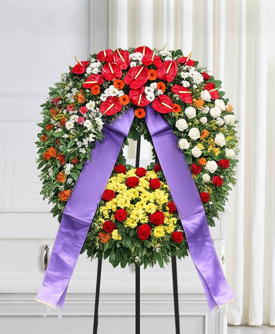 Corona funebre con fiori dai toni caldi