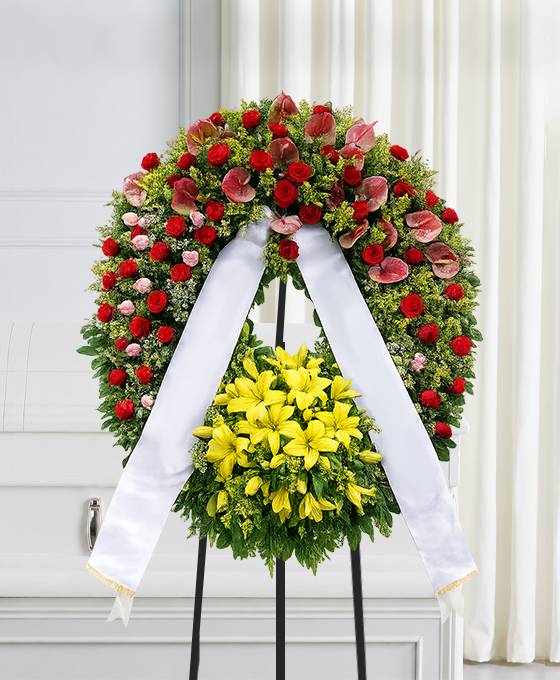 Corona funebre con fiori di stagione dai colori caldi
