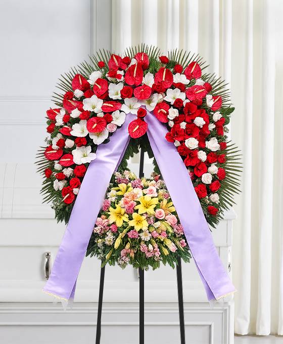 Corona funebre in rosso e bianco con fiori colorati