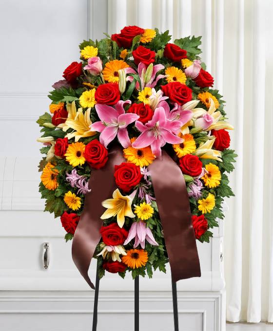 Cuscino funebre di fiori dai toni caldi